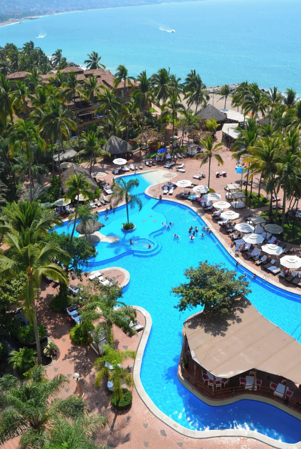 View from Fiesta Americana Puerto Vallarta & Spa at Fiesta Americana Puerto Vallarta & Spa over pools, palms, and ocean.