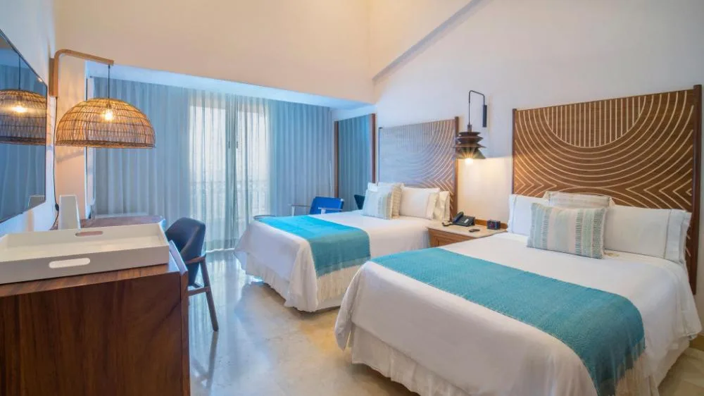 Fiesta Americana Puerto Vallarta & Spa room with two beds and turquoise accents at Fiesta Americana Puerto Vallarta & Spa.