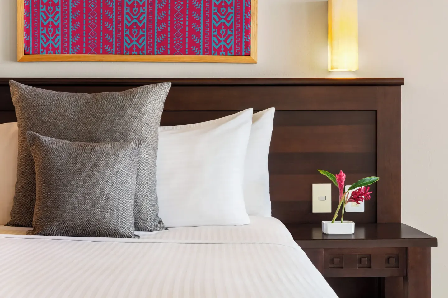 Close-up of a guest room bed and bedside flowers at Fiesta Americana Riviera Nayarit Resort & Spa.