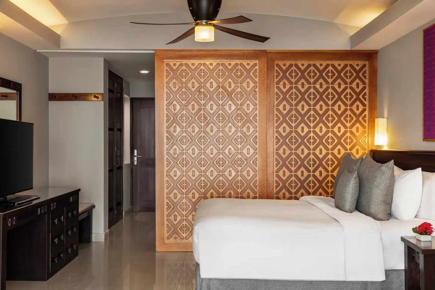 King bed, patterned closet panels, and TV console at Fiesta Americana Riviera Nayarit Resort & Spa.