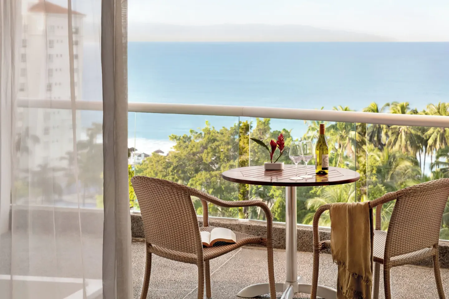 Balcony with wicker chairs and ocean view at Fiesta Americana Riviera Nayarit Resort & Spa.