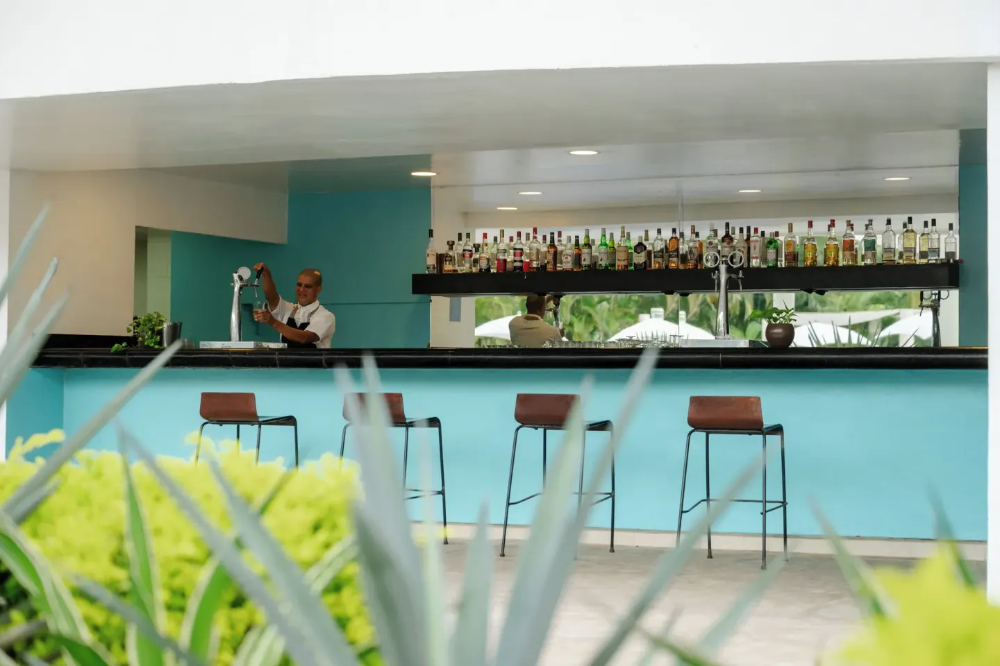 Outdoor bar with stools and bottle display at Fiesta Americana Riviera Nayarit Resort & Spa.