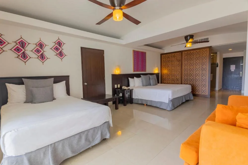 Family Junior Suite with two beds and orange sofa at Fiesta Americana Riviera Nayarit Resort & Spa.
