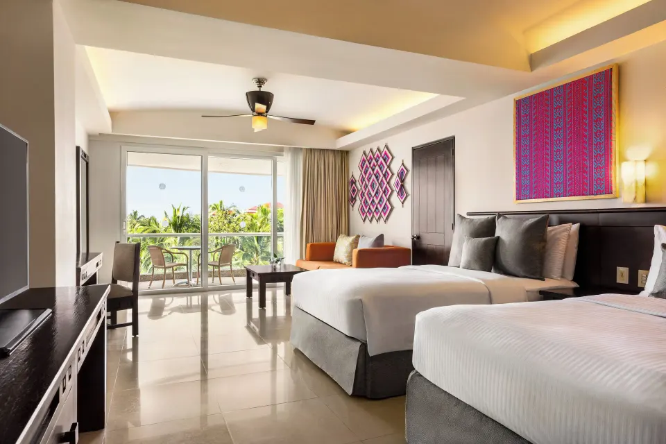 Junior Suite with two beds, TV, and tropical balcony at Fiesta Americana Riviera Nayarit Resort & Spa.