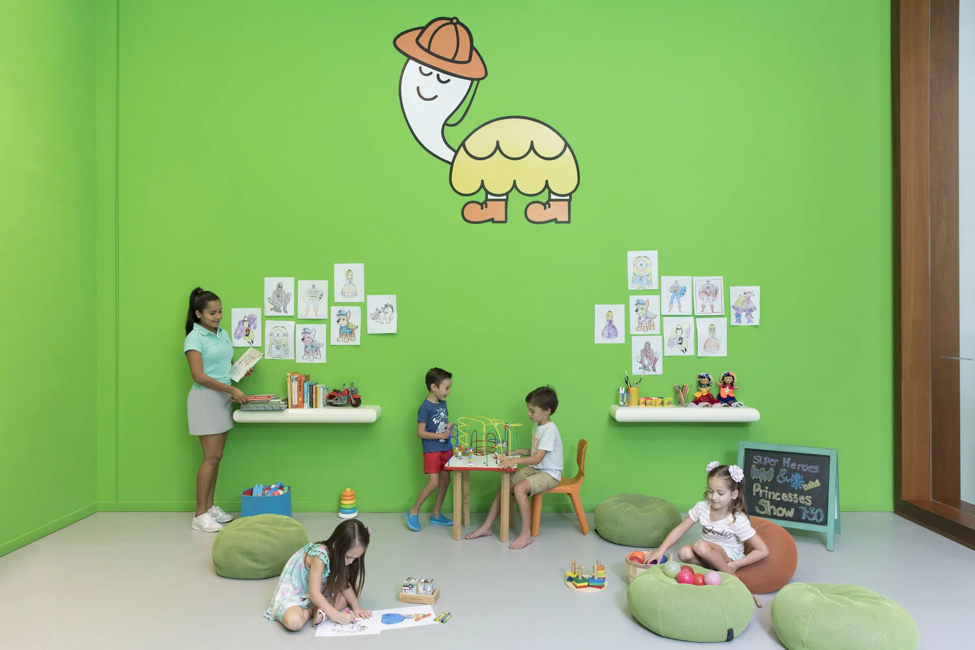 Children play in a bright green kids club room at Finest Playa Mujeres.