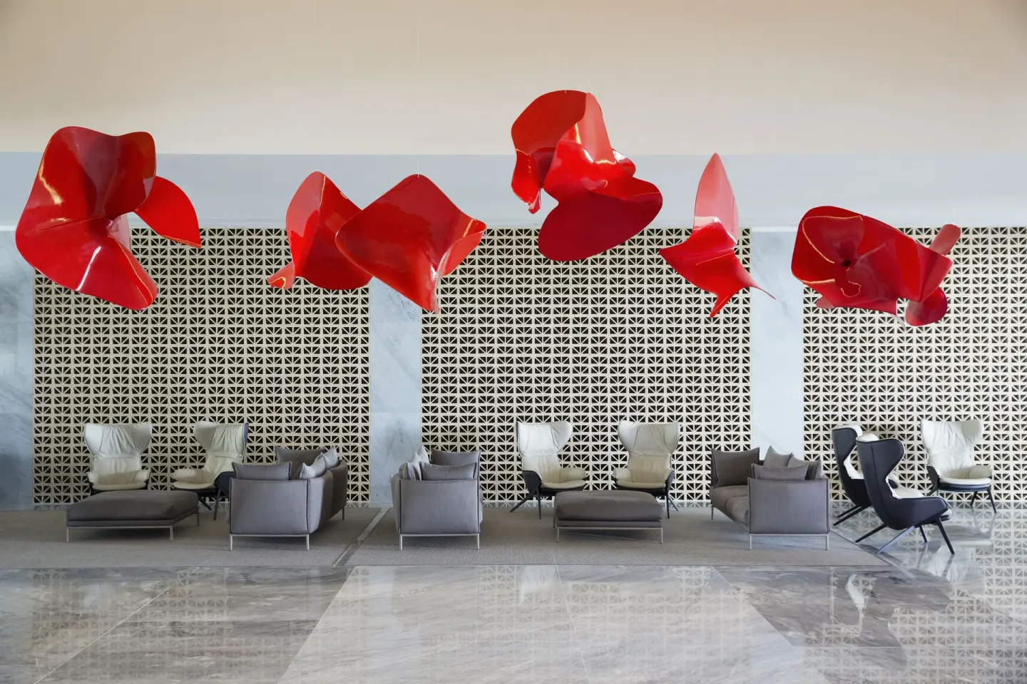 Lobby lounge with red hanging sculptures and patterned wall at Finest Playa Mujeres.