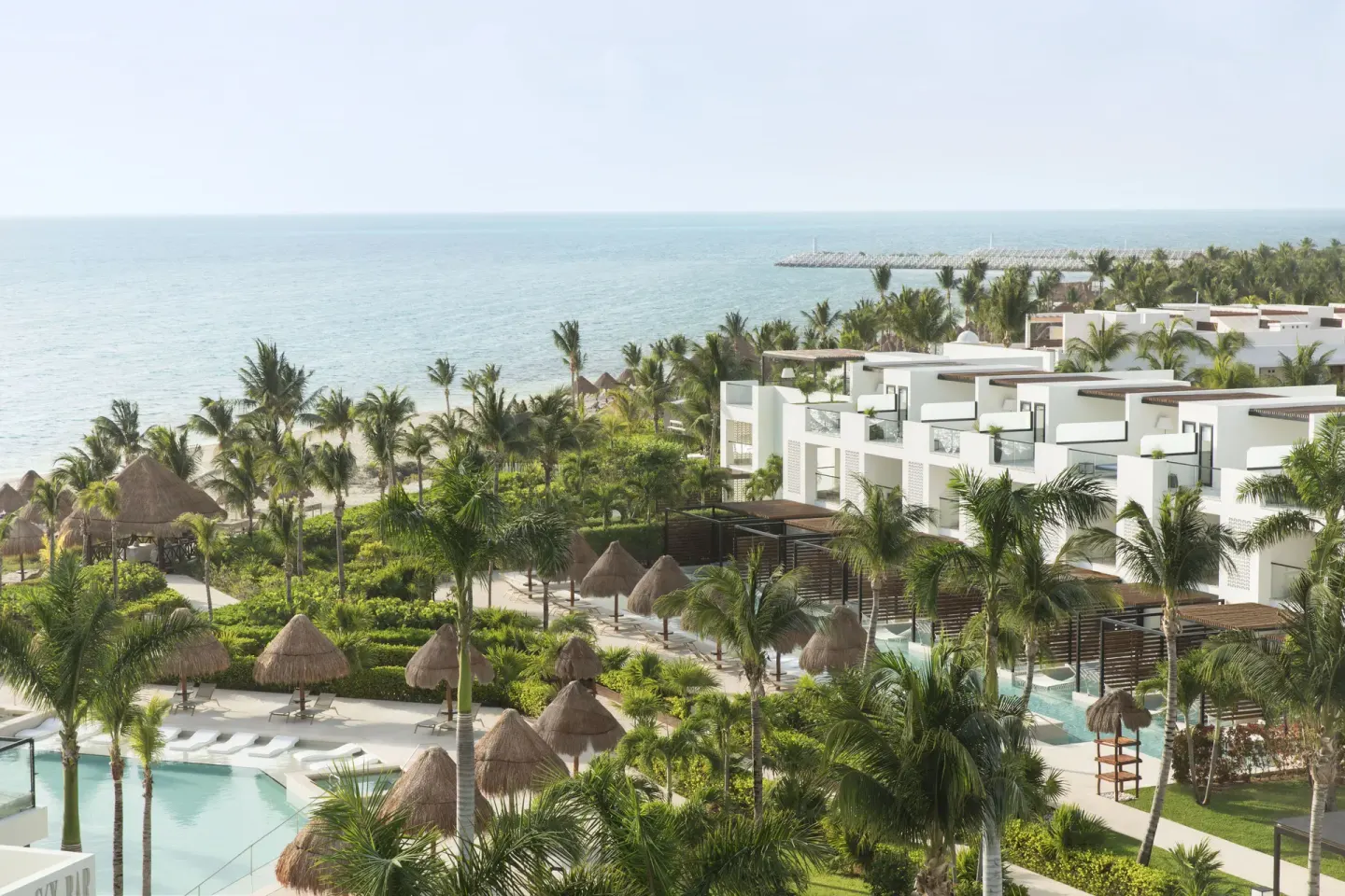 White guest room buildings, palms and ocean views at Finest Playa Mujeres.
