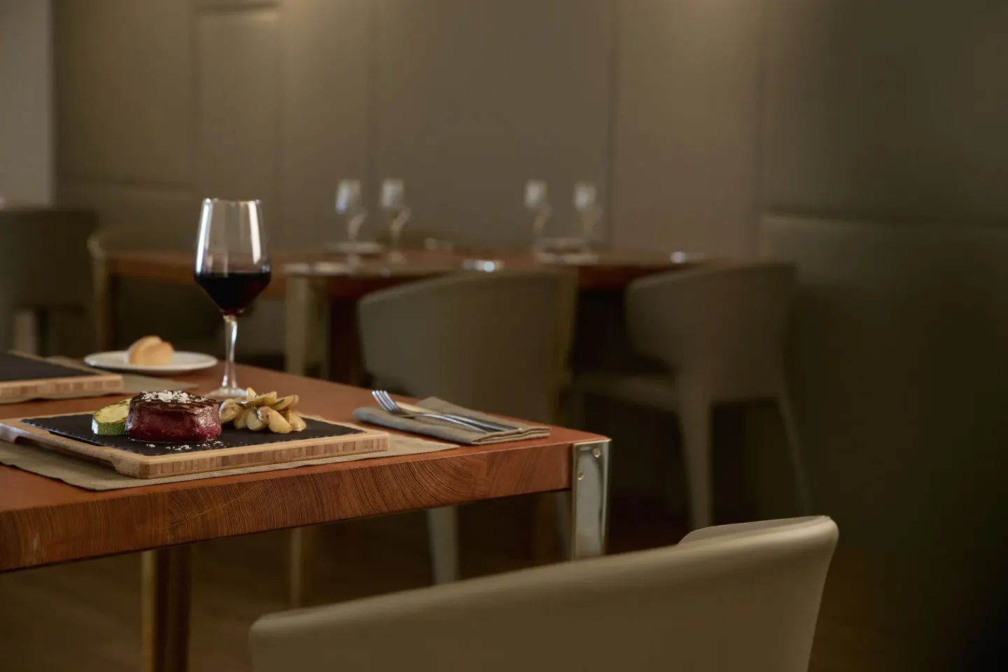 Steak entrée with red wine served in a dining room at Finest Playa Mujeres.