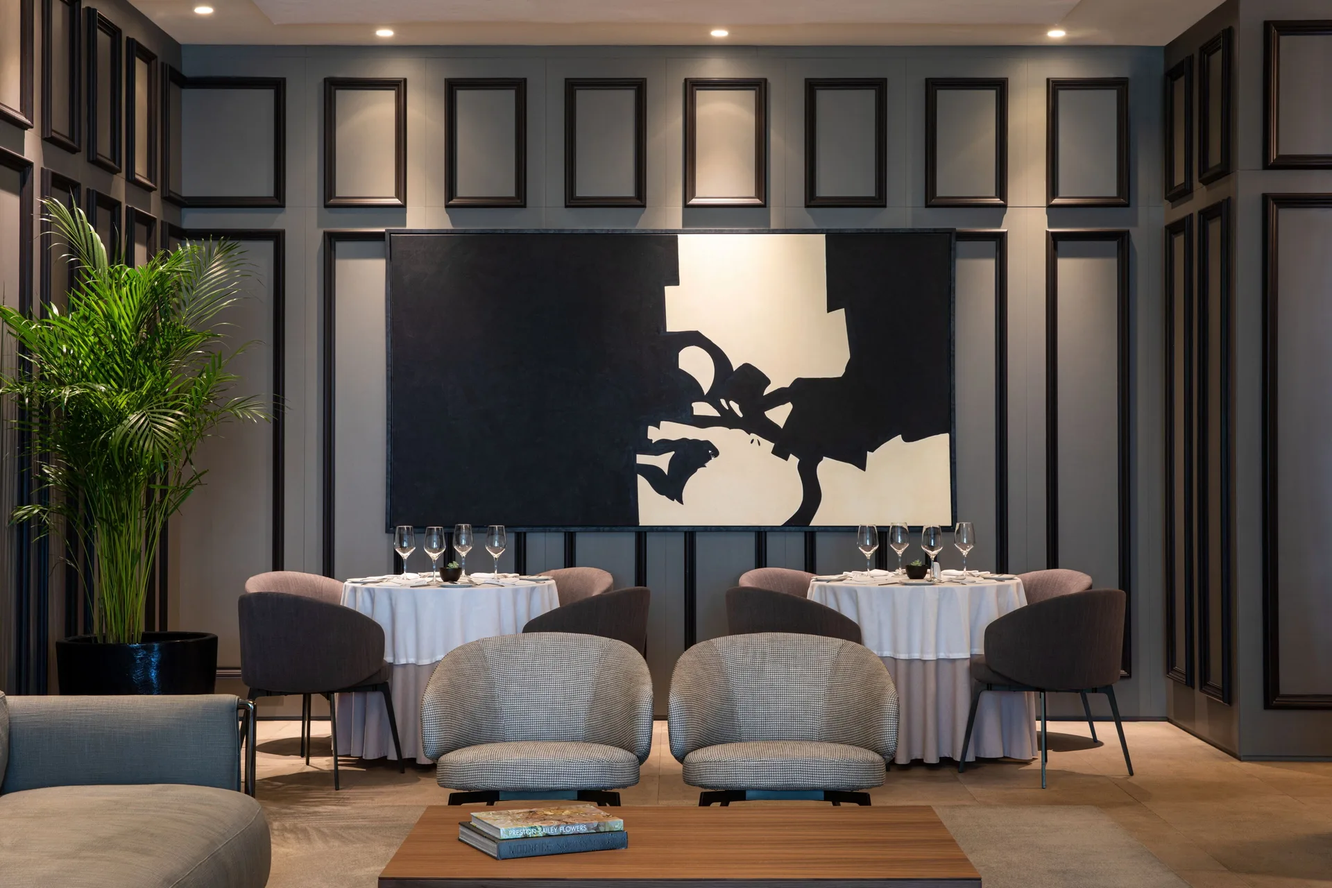 Elegant dining room with round tables and abstract artwork at Finest Playa Mujeres.
