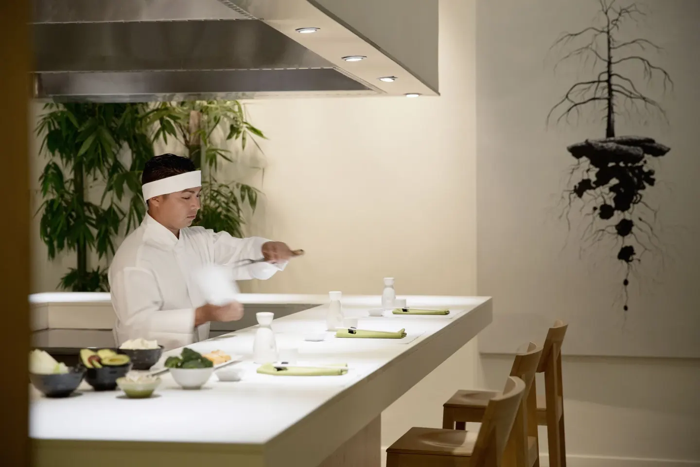 Chef preparing sushi at a bright dining counter at Finest Playa Mujeres.