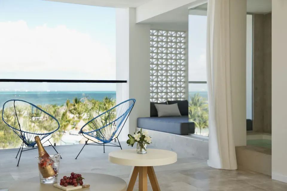 Excellence Club Junior Suite Ocean View terrace with blue chairs at Finest Playa Mujeres.