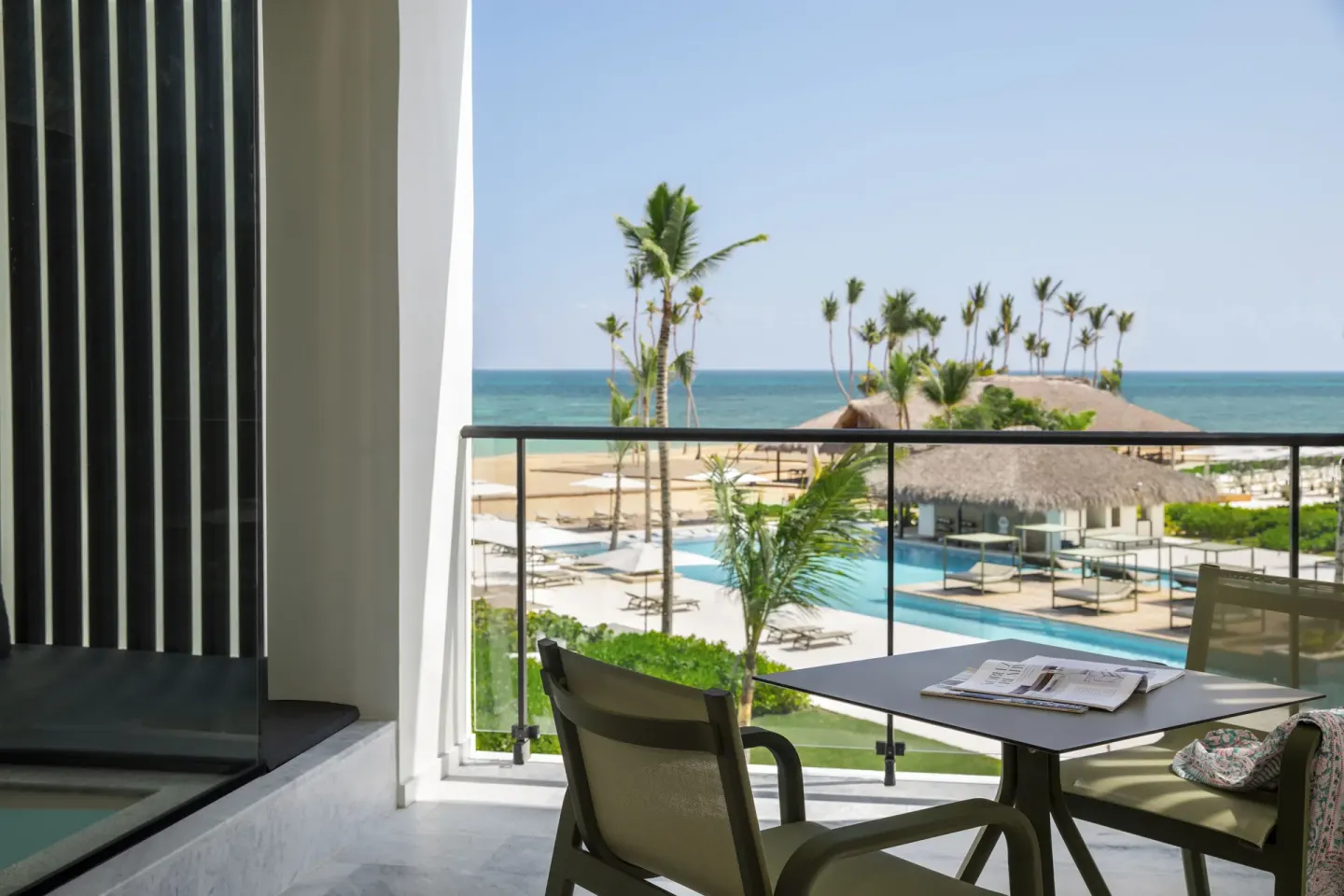Balcony seating with pool, palms, beach, and ocean views at Finest Punta Cana.