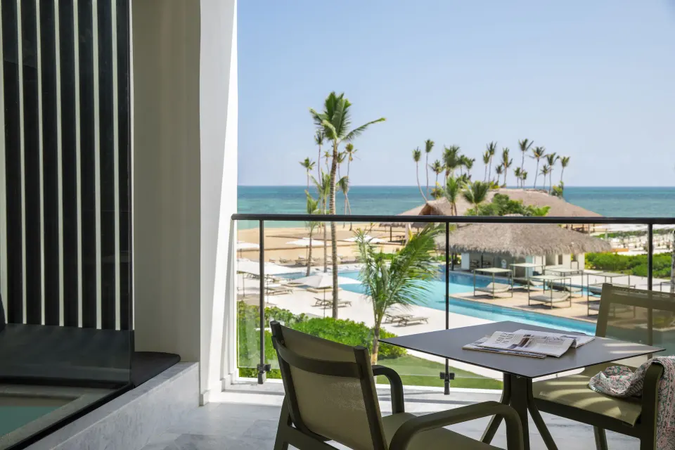 Balcony seating with pool, palms, beach, and ocean views at Finest Punta Cana.