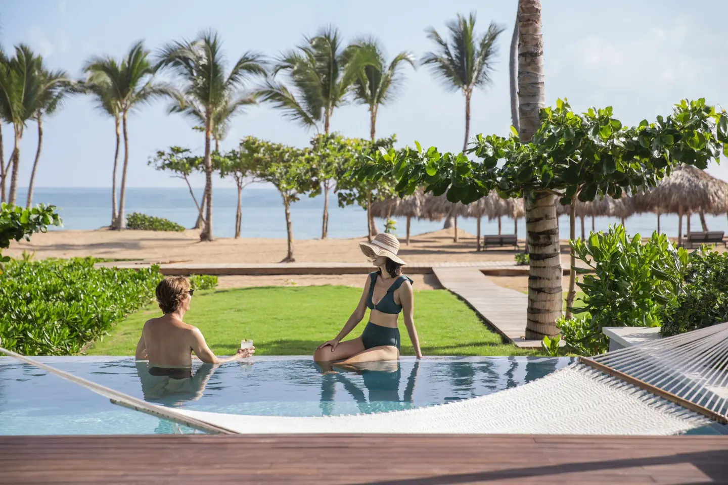 Couple in a swim-up pool facing the beach and palms at Finest Punta Cana.