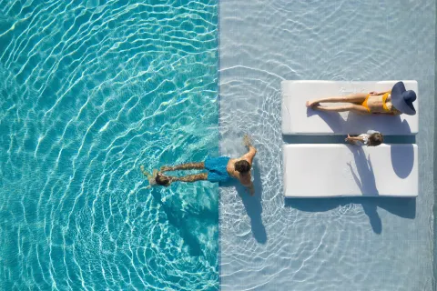 Overhead pool scene with family and in-water loungers at Finest Punta Cana.