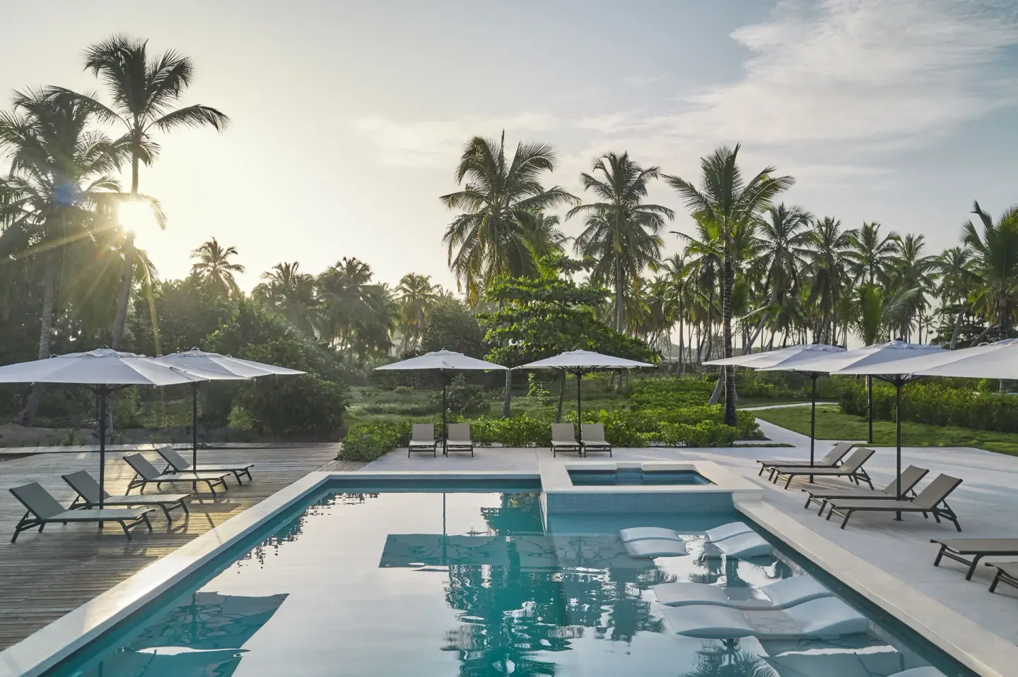 Quiet pool with loungers, umbrellas, palms, and landscaped paths at Finest Punta Cana.