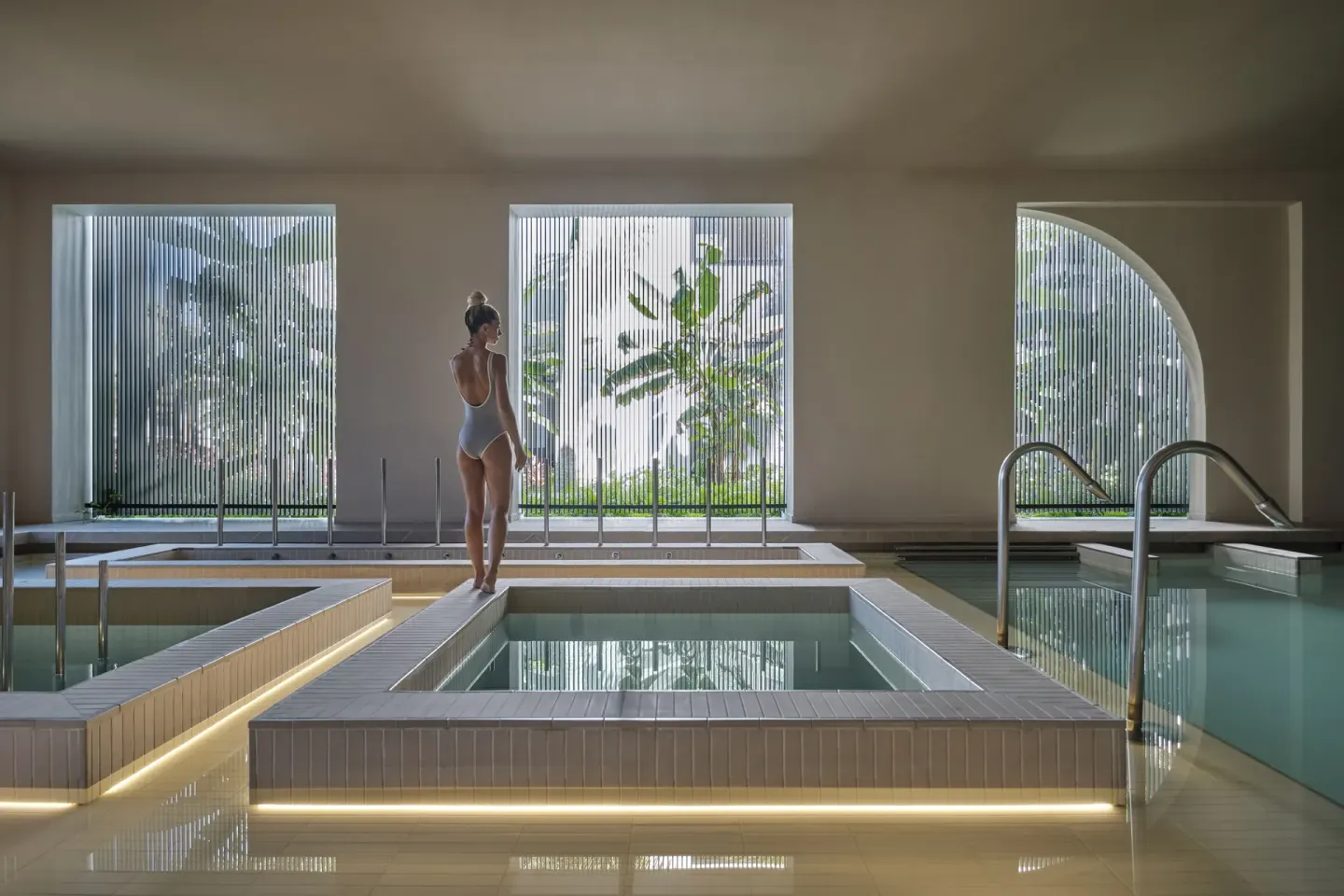 Indoor hydrotherapy pools with a guest in the spa at Finest Punta Cana.