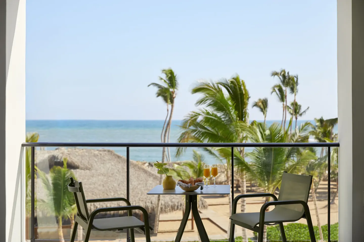 Balcony table with breakfast drinks and an ocean view at Finest Punta Cana.
