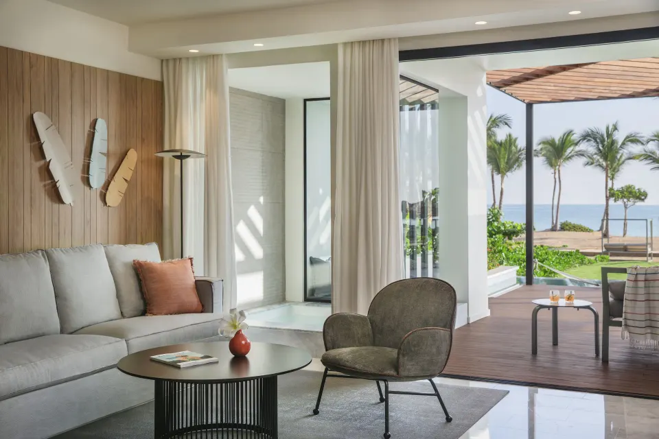 Oceanfront suite lounge with sofa, chair, and terrace at Finest Punta Cana.