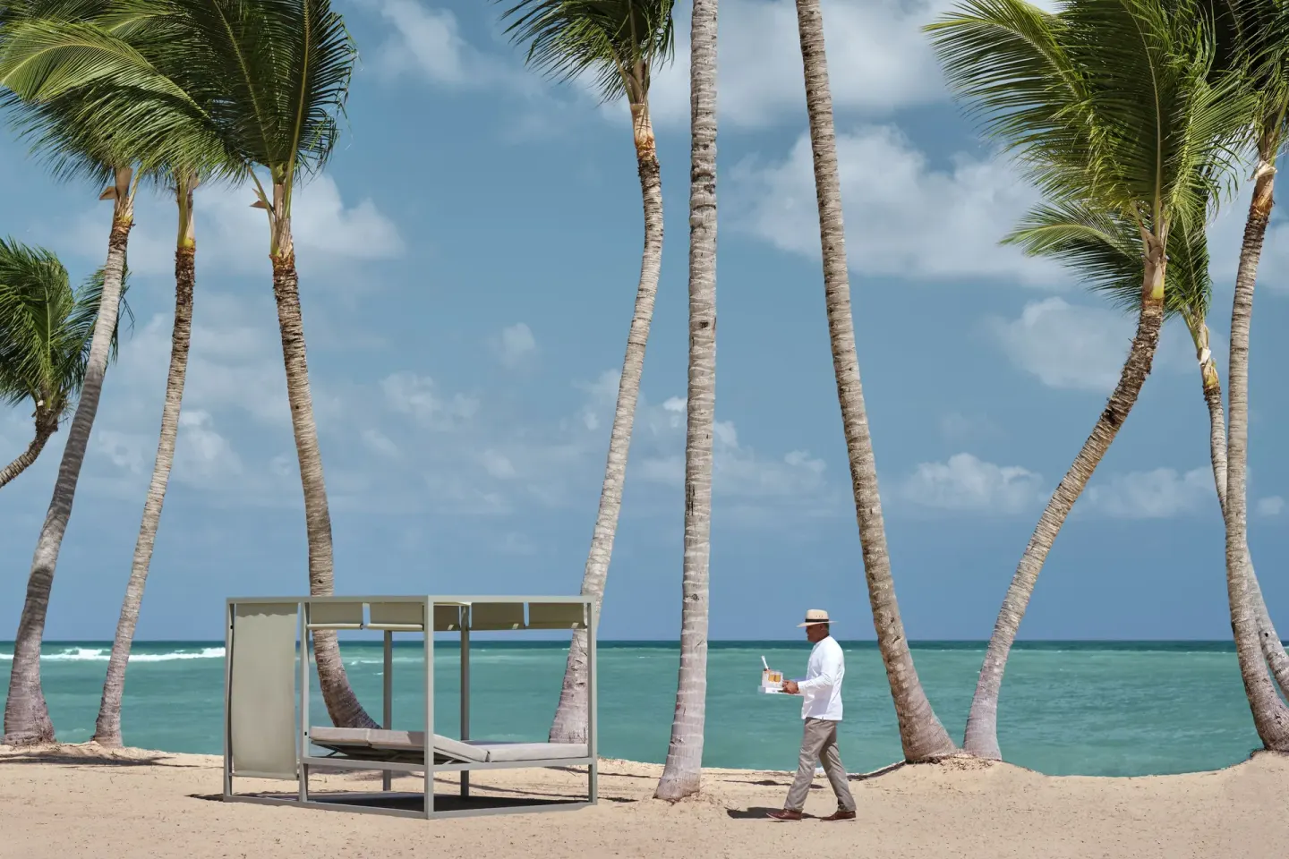 Palm-lined beach with a shaded daybed at Finest Punta Cana.