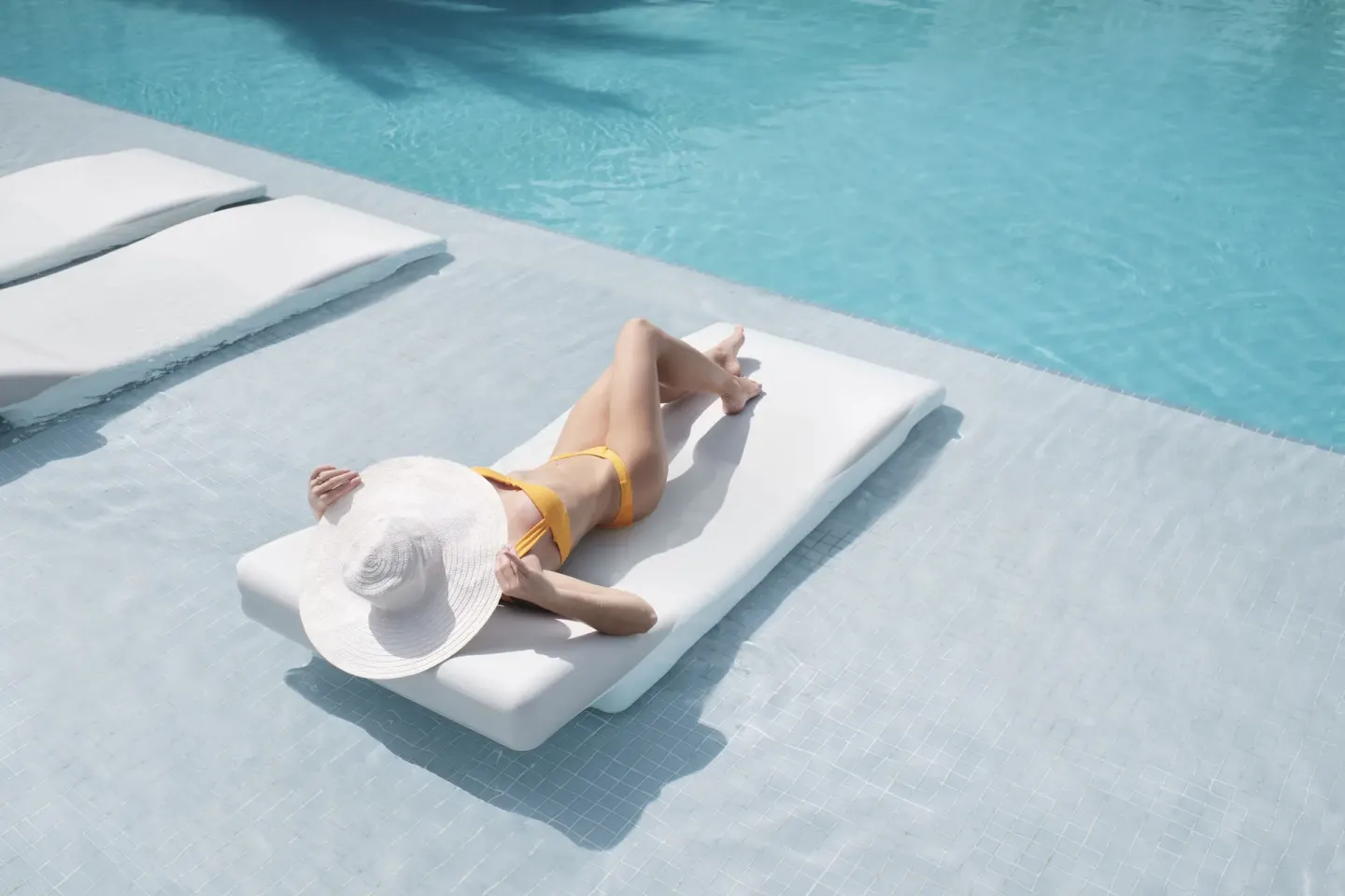 Sunbather reclining on a white in-pool lounger at Finest Punta Cana.