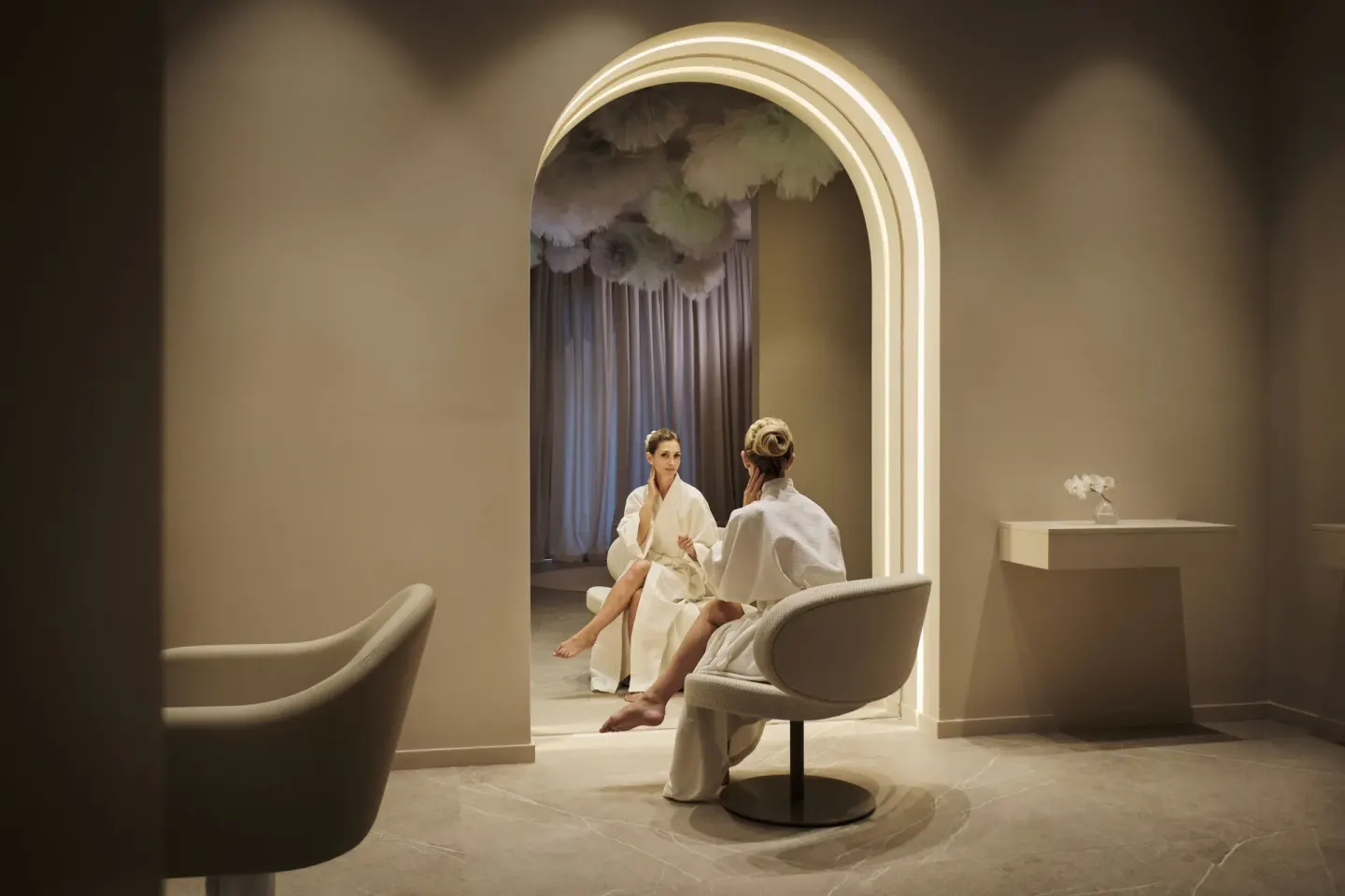 Spa lounge with two robe-clad guests beneath an illuminated arch at Finest Punta Cana.