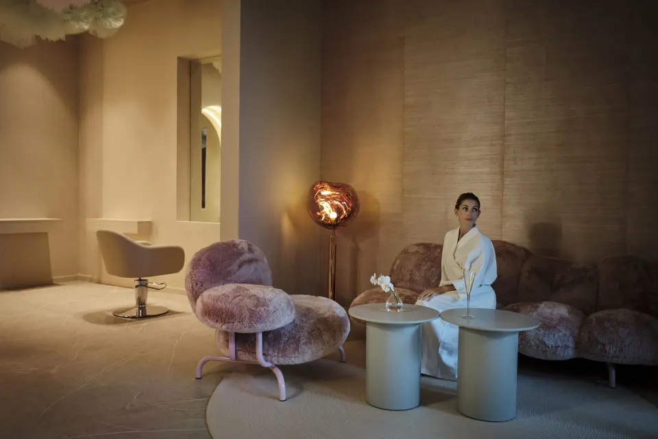 Spa relaxation lounge with plush pink seating and a robe-clad guest at Finest Punta Cana.