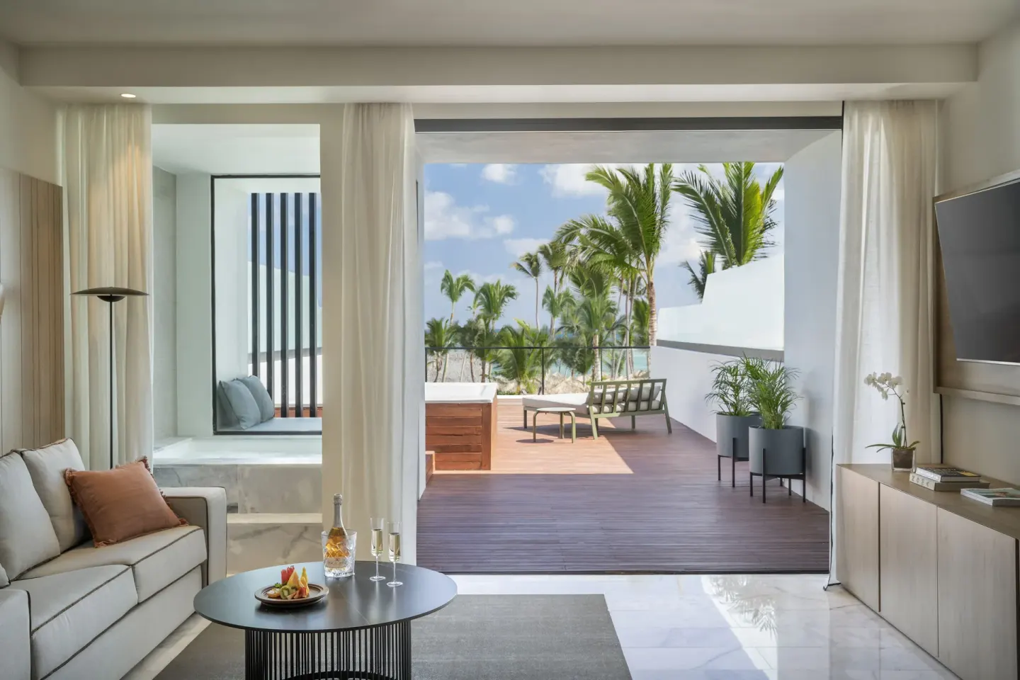 Suite living area opening to a private terrace with palm views at Finest Punta Cana.