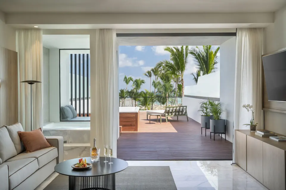 Suite living area opening to a private terrace with palm views at Finest Punta Cana.