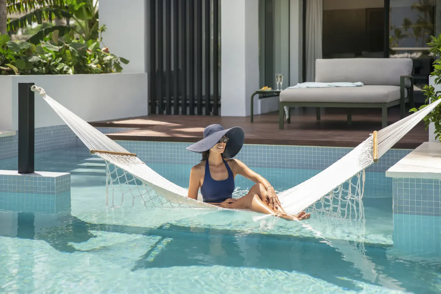 Guest relaxing in a hammock over a swim-up pool at Finest Punta Cana.