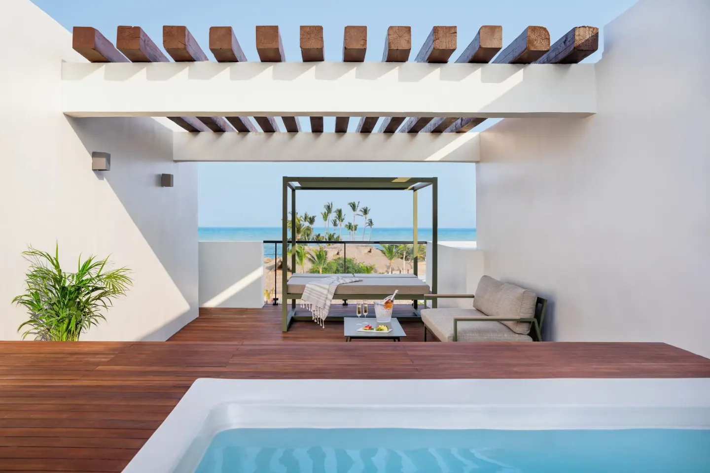 Rooftop-style terrace with plunge pool, daybed, sofa, and ocean view at Finest Punta Cana.