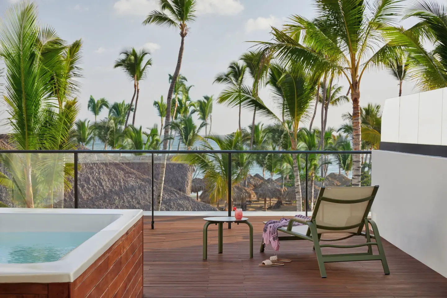 Terrace with plunge pool, lounger, and palm-framed ocean view at Finest Punta Cana.