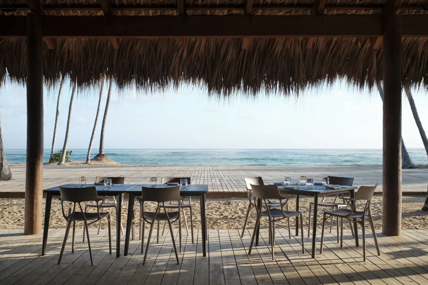 Beachfront tables under a thatched roof face the ocean at Finest Punta Cana.