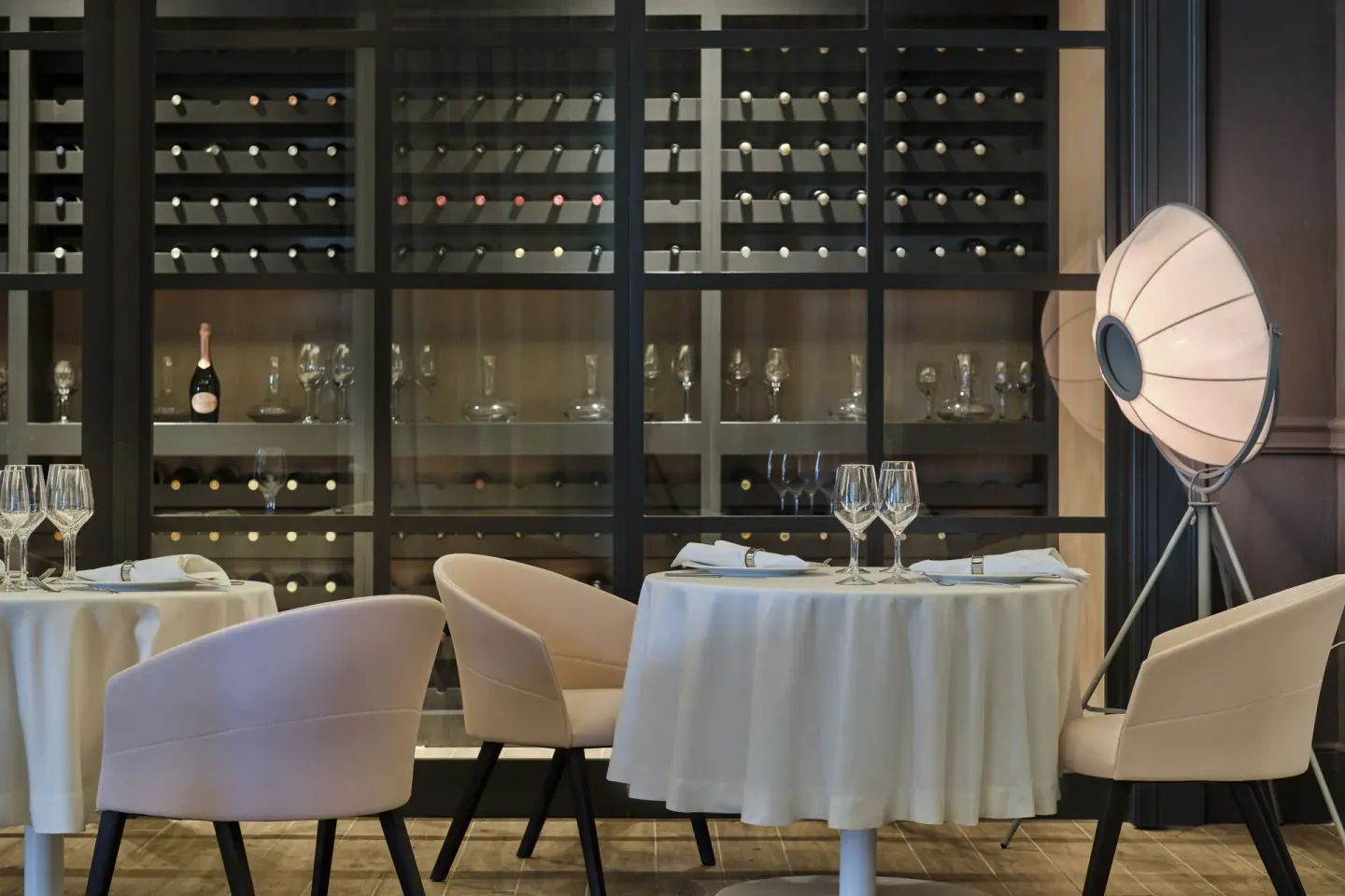 Elegant dining room with wine display and round tables at Finest Punta Cana.