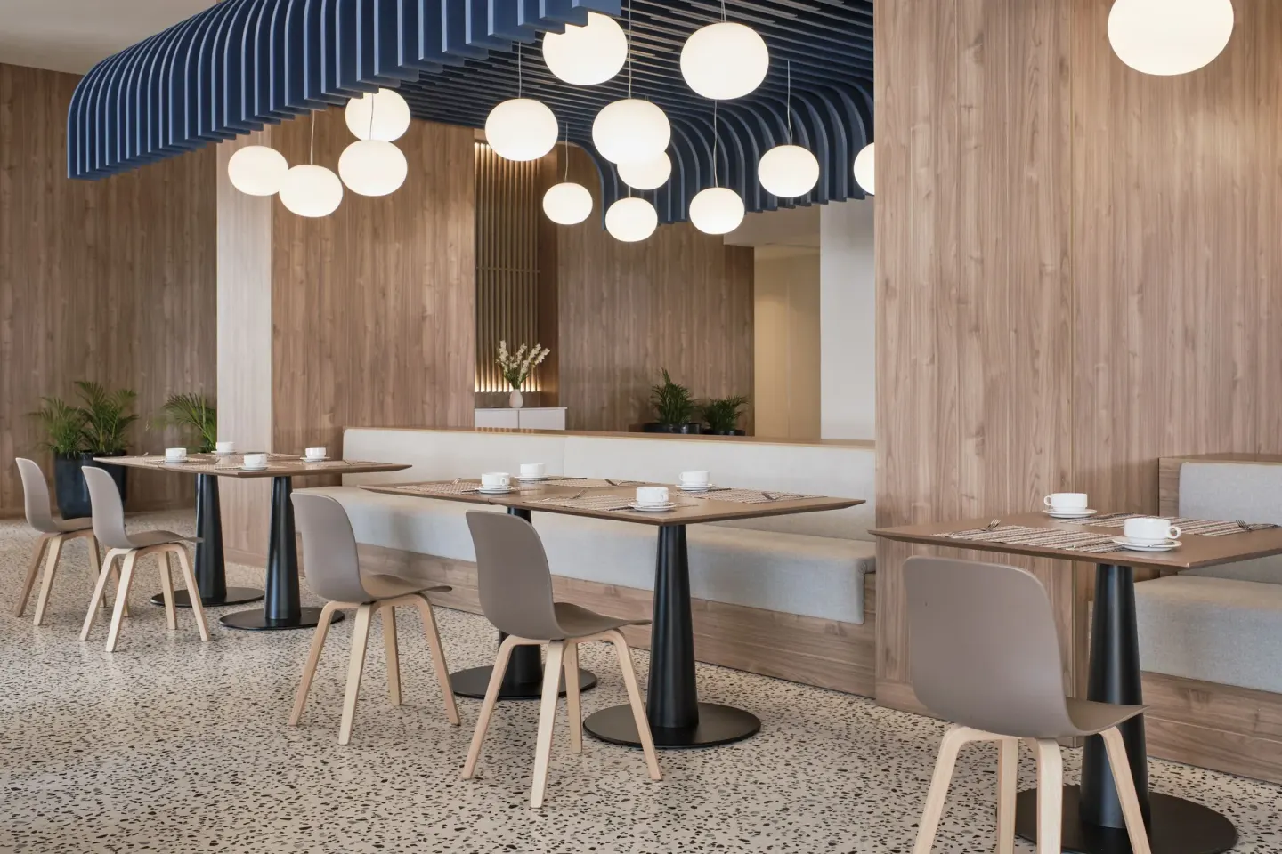 Modern dining room with wood walls and globe pendant lights at Finest Punta Cana.