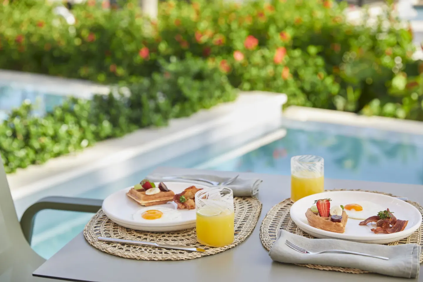 Breakfast plates and orange juice beside a private pool at Finest Punta Cana.