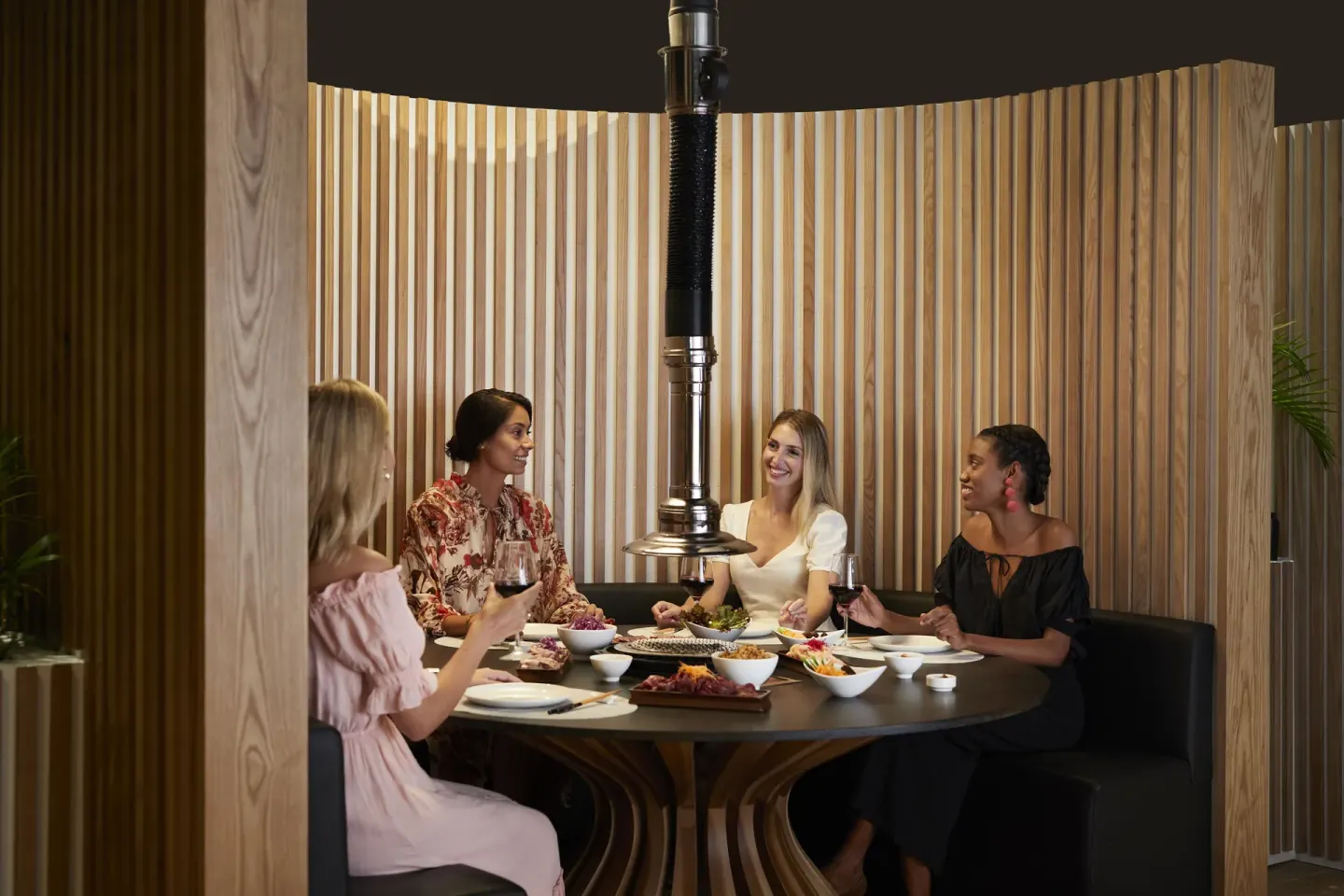 Guests share a meal around a round grill table at Finest Punta Cana.