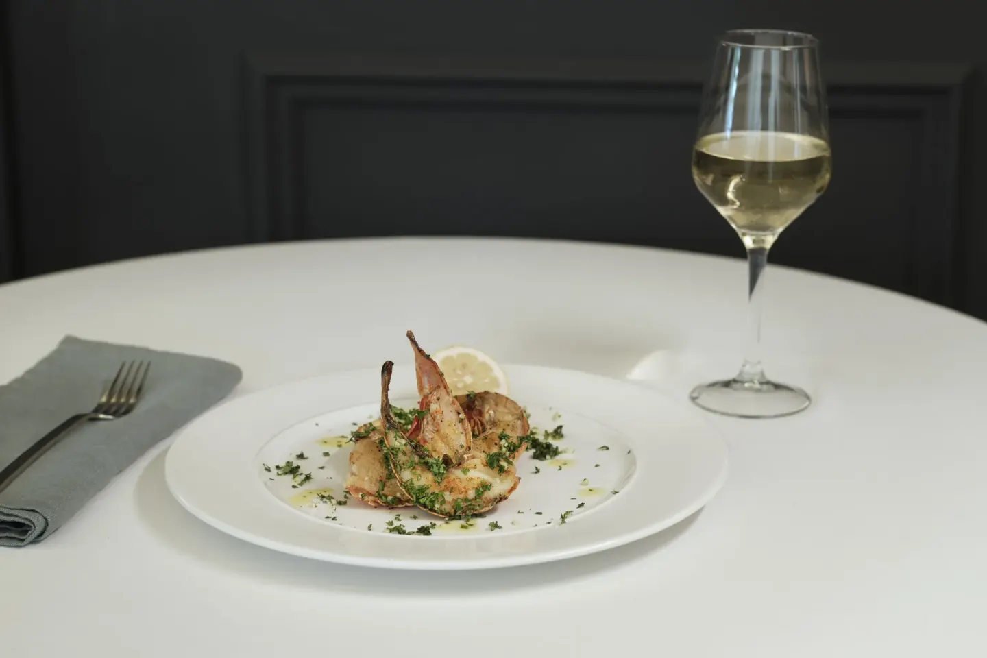 Plated seafood dish with a glass of white wine at Finest Punta Cana.