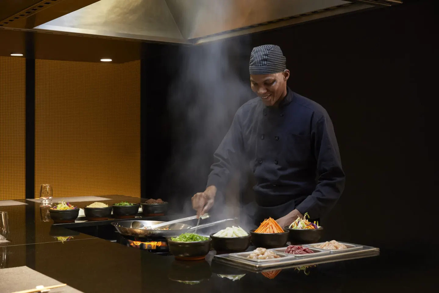 Chef cooks vegetables on a steaming hot station at Finest Punta Cana.