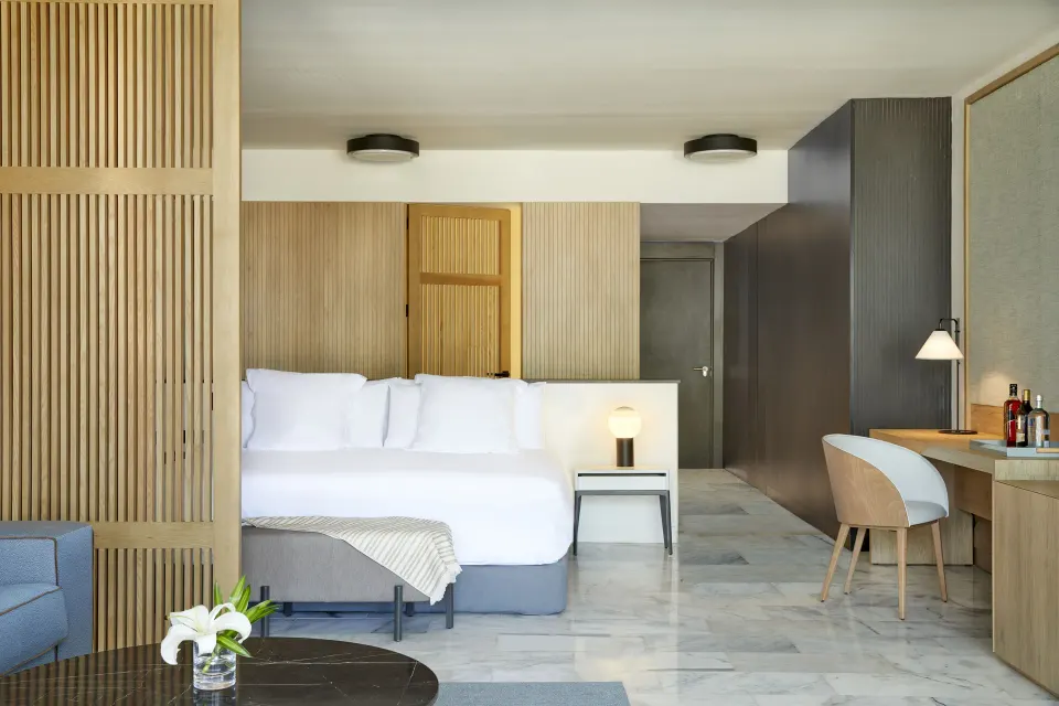 Excellence Club Suite bedroom with king bed, desk, sofa, and marble floor at Finest Punta Cana.