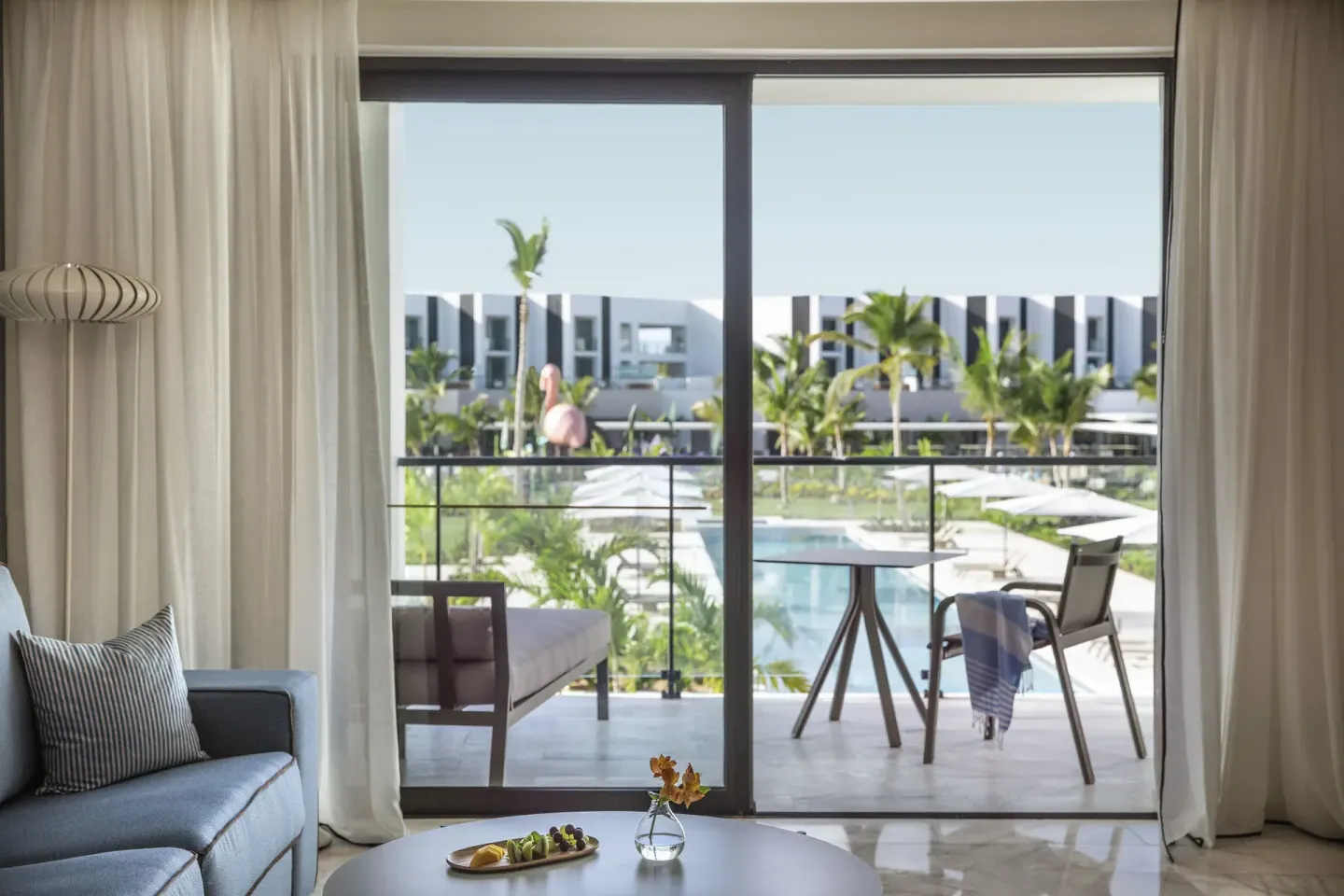 Family Suite living area and balcony overlooking the pool at Finest Punta Cana.