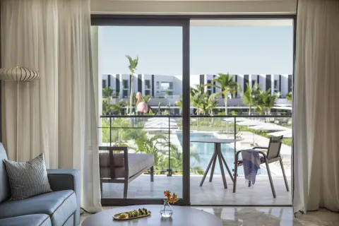 Family Suite living area and balcony overlooking the pool at Finest Punta Cana.