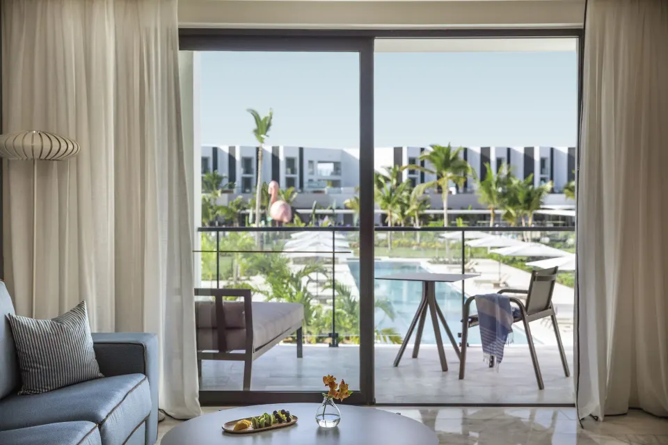 Family Suite living area and balcony overlooking the pool at Finest Punta Cana.