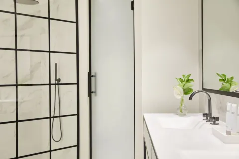 Junior Suite bathroom with shower, vanity, and mirror at Finest Punta Cana.