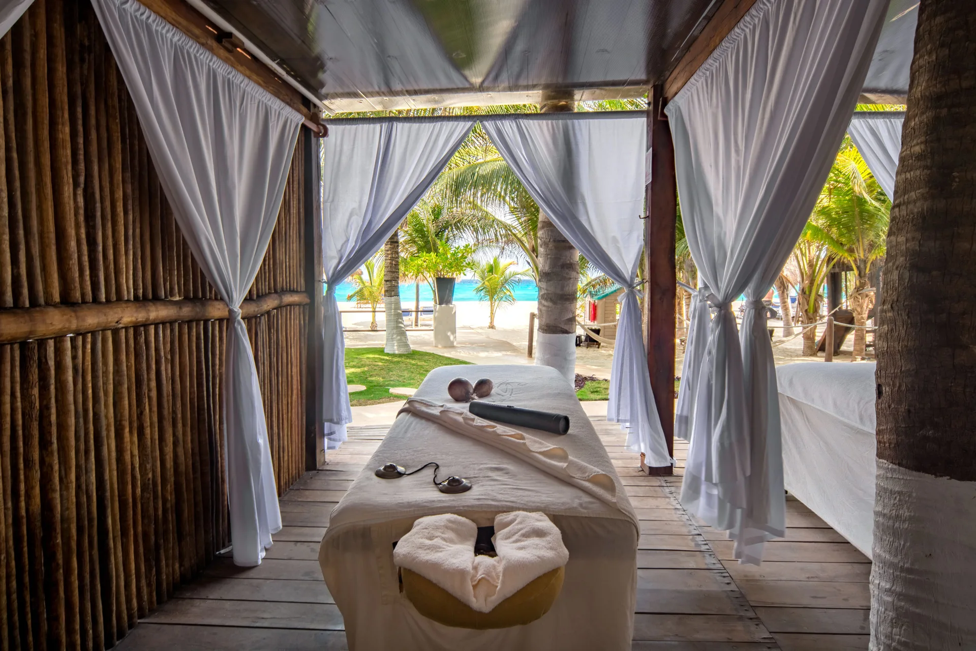 Massage table in a curtained beach cabana facing the sea at Flamingo Cancun.