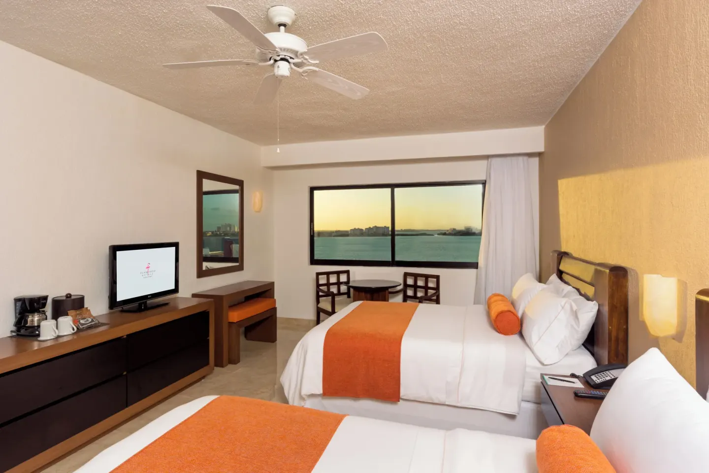 Guest room with two double beds and a lagoon-facing window at Flamingo Cancun.