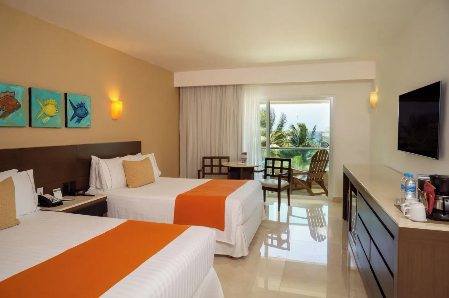Two-bed guest room with balcony seating and partial ocean view at Flamingo Cancun.