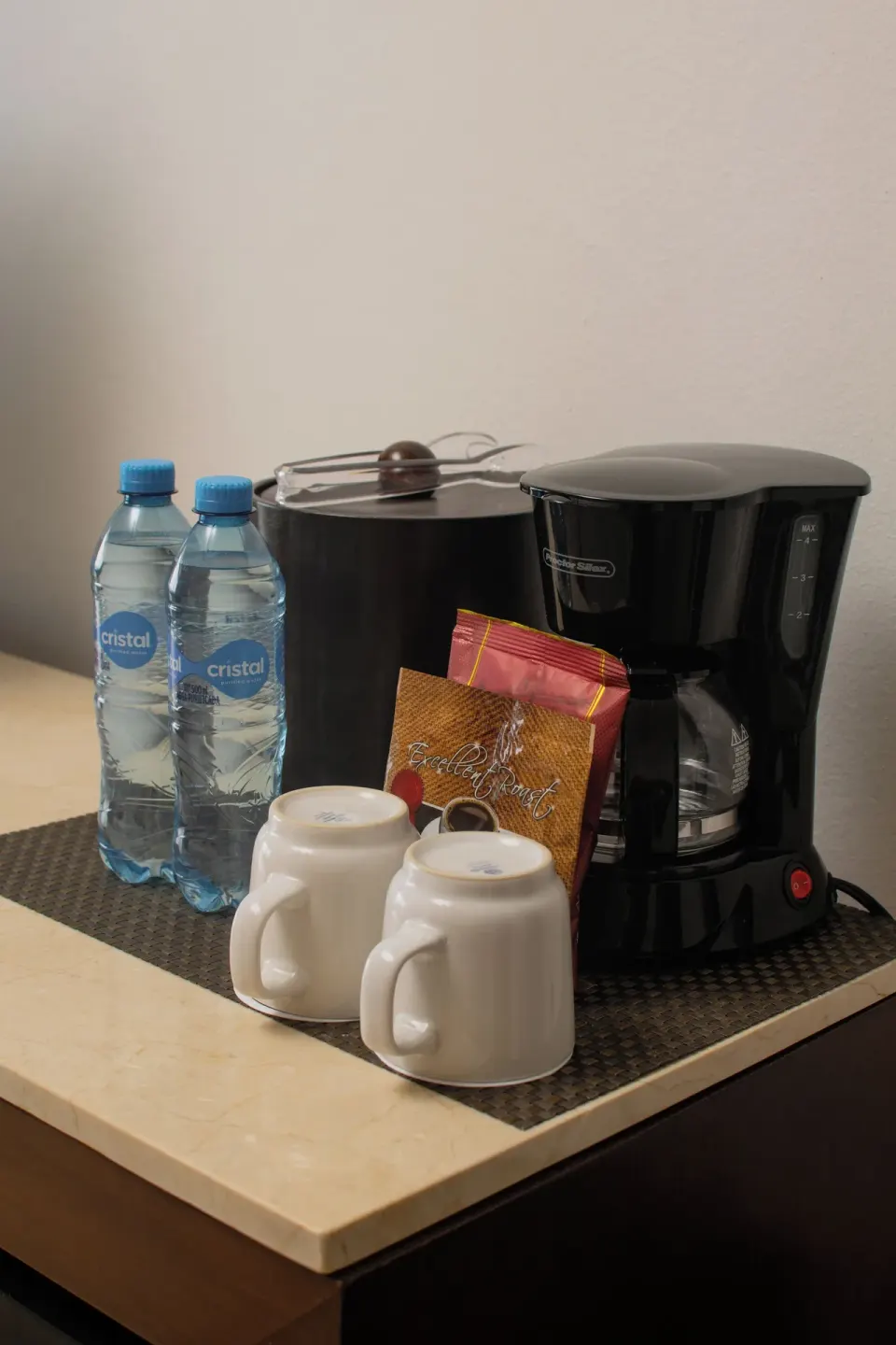 In-room coffee maker with mugs and bottled water at Flamingo Cancun.