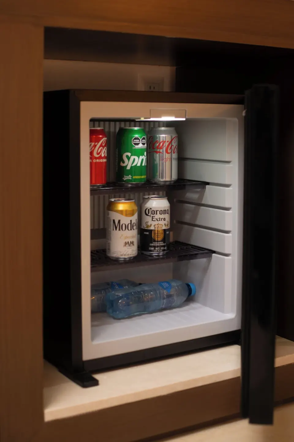 Open in-room mini fridge stocked with drinks at Flamingo Cancun.