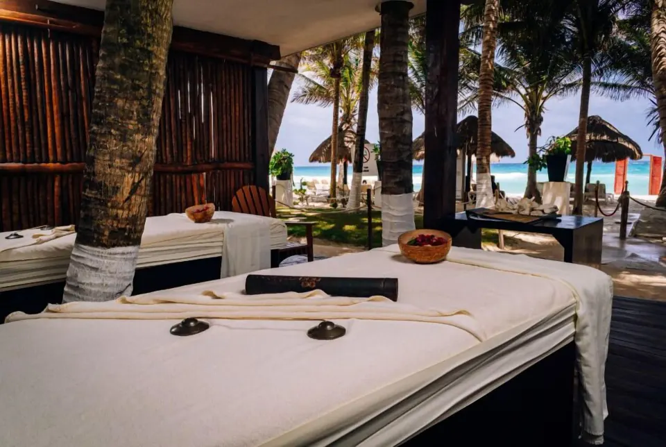 Open-air spa area with massage beds under palms by the beach at Flamingo Cancun.